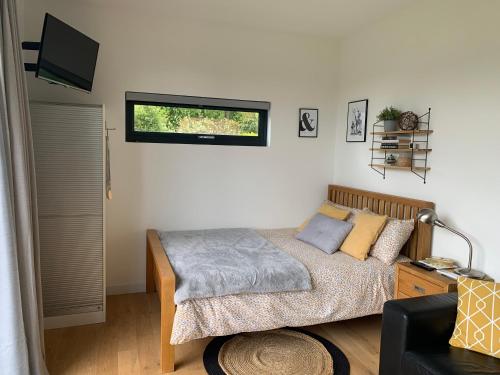 a bedroom with a bed and a television in it at Cedar Cabin in Newbury