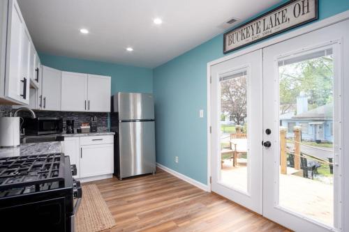 une cuisine avec des murs bleus et un réfrigérateur dans l'établissement Buckeye Lake Cottage, à Hebron