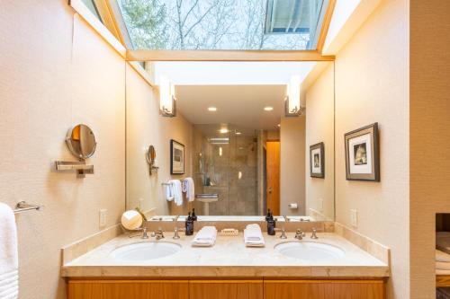 ein Badezimmer mit zwei Waschbecken und einem großen Fenster in der Unterkunft Luxury Warm Springs Creekfront Home in Ketchum