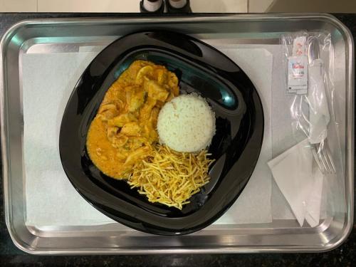 un plato de comida con fideos y arroz en un microondas en Prestige Motel 4 en Sorocaba