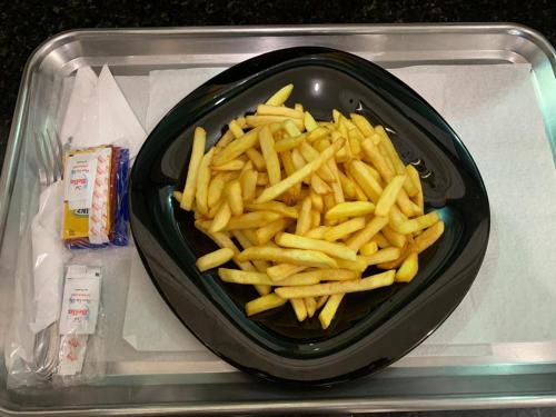 a pile of french fries in a black bowl at Prestige Motel 4 in Sorocaba