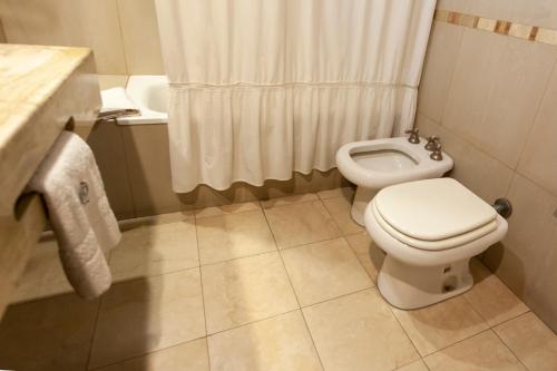 a bathroom with a toilet and a shower at Hotel Catalinas Tucuman in San Miguel de Tucumán