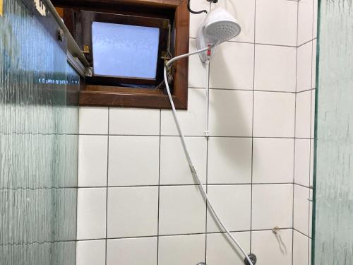een douche met een douchekop in de badkamer bij Pousada DRIRIOS HOUSE in Jaraguá do Sul
