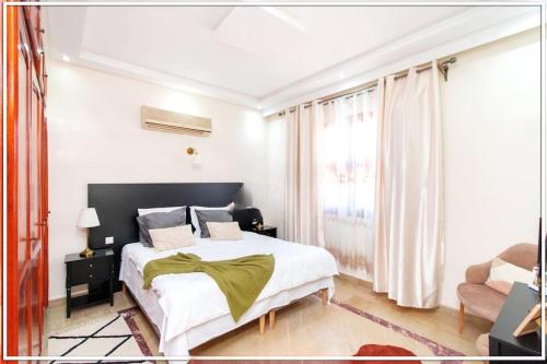 um quarto com uma grande cama branca e um sofá em Fabuleuse Villa Marrakchi em Marrakech