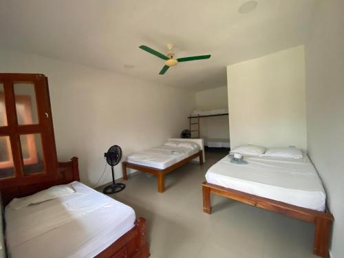 Habitación con 2 camas y ventilador de techo. en hotel palmares beach en Palomino