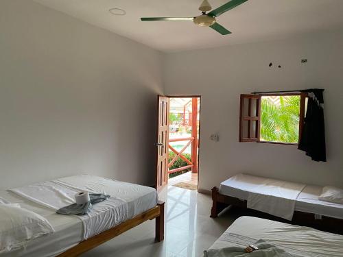 a bedroom with two beds and a ceiling fan at hotel palmares beach in Palomino