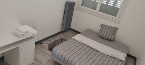 - une petite chambre avec un lit et une fenêtre dans l'établissement Chambre dans Appartement - Grenoble, France à 8 min du centre-ville, à Grenoble