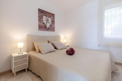 a bedroom with a white bed with a flower on it at 50 meters from CALA CRANCS- Terrace and seaviews in Salou