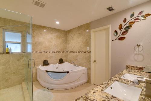 y baño con bañera y ducha acristalada. en Spacious Freeport Home with Private Pool and Lake View, en Freeport