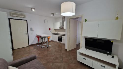 ein Wohnzimmer mit einem Sofa und einem TV sowie eine Küche in der Unterkunft Dolcenido Meyer Firenze in Florenz