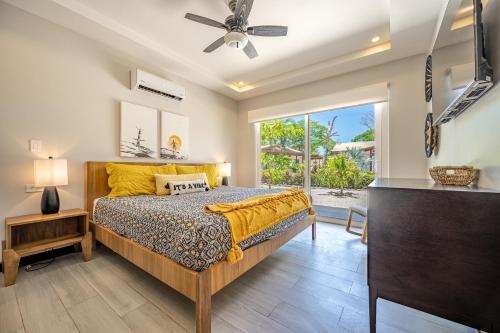 a bedroom with a bed and a large window at The Breakhouse in Playa Avellana