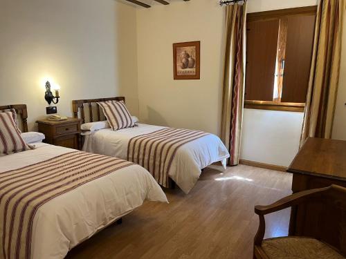 Habitación de hotel con 2 camas y ventana en Hotel A Posada en Tembleque