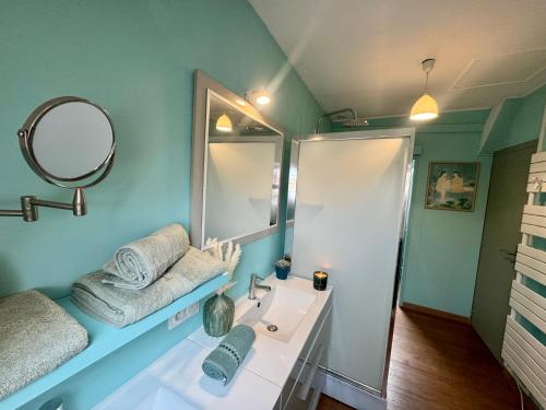 ein Bad mit einem Waschbecken und einem Spiegel in der Unterkunft Le Repos des Rias, maison au cœur de la ville in Quimperlé