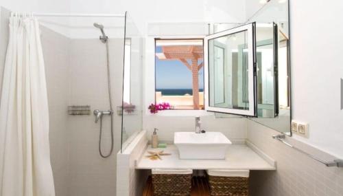 a white bathroom with a sink and a shower at Las Casas de Mar Atlanterra in Zahara de los Atunes