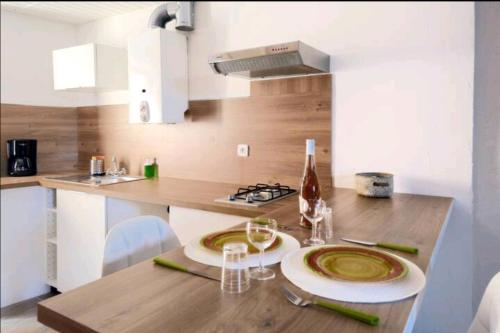 une cuisine avec une table avec des assiettes et des verres à vin dans l'établissement studio idéalement placé, calanques et centre ville, à La Ciotat