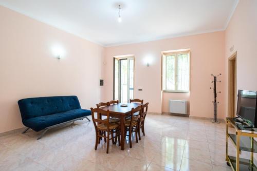a living room with a table and a blue couch at Grace's House in Acireale