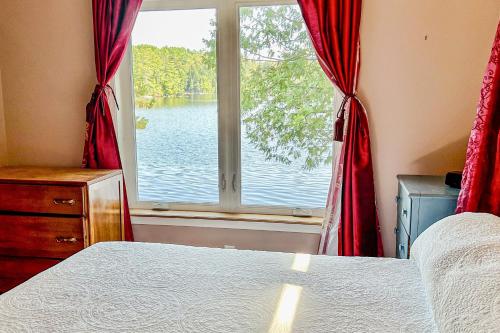 Schlafzimmer mit einem Fenster mit Blick auf das Wasser in der Unterkunft Evergreen Cottage in Norway