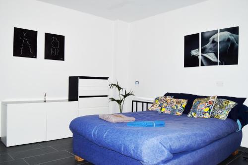 Un dormitorio con una cama azul con cuadros en la pared en Monolocale di 55mq in villa 8km da Pompei, en San Giuseppe Vesuviano