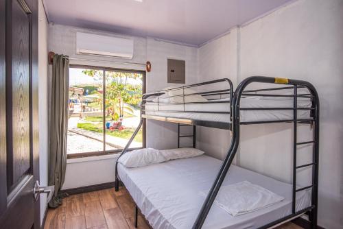 a bunk bed in a room with a window at Casa, 3 dormitorios, piscina, rancho, cocina, minibar, pingpong, 9 personas in Capulín