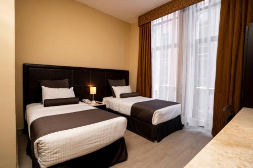 ein Hotelzimmer mit 2 Betten und einem Fenster in der Unterkunft Hotel San Francisco in San Luis Potosí