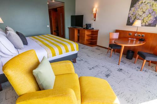 a hotel room with a bed and a couch and a table at Park Lake Luxury Hotel in Pucón