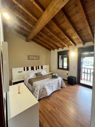 1 dormitorio con 1 cama grande y suelo de madera en A MIÑA CASIÑA -TERMAS OURENSE, en Ourense