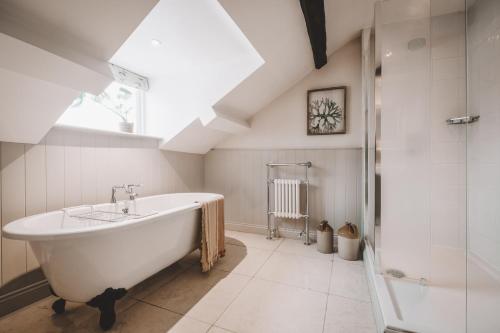 a white bathroom with a tub and a shower at The Hare & Hounds Inn in Bowland Bridge
