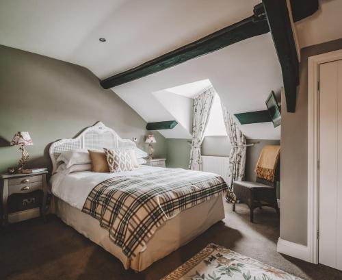 a bedroom with a bed and a chair and a window at The Hare & Hounds Inn in Bowland Bridge