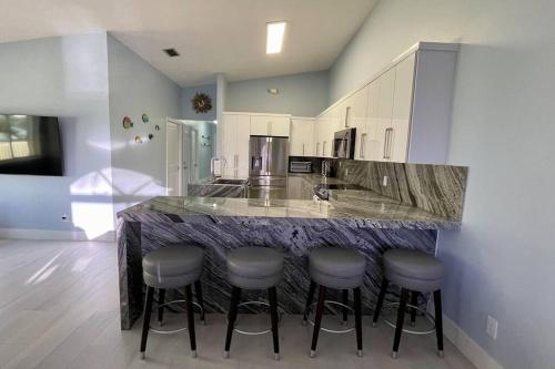 a kitchen with a counter with stools around it at Easy Ocean Access 30' Dock - House - Private Club w/ Heated Pool and Sandy Beach in Key Colony Beach