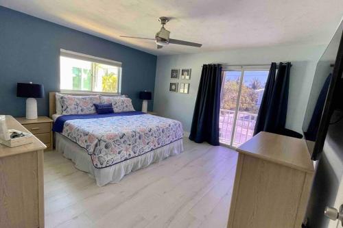 a bedroom with a bed and a television in it at Easy Ocean Access 30' Dock - House - Private Club w/ Heated Pool and Sandy Beach in Key Colony Beach
