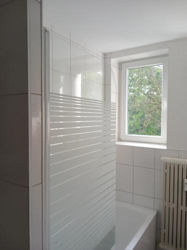 biała łazienka z prysznicem i oknem w obiekcie City Apartment Duisburg 2#Netflix &Wlan &Kingsize Bett &Central w mieście Duisburg