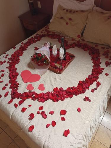 a bed with a heart made out of red roses at HOTEL PLAZA VASCO in Pátzcuaro
