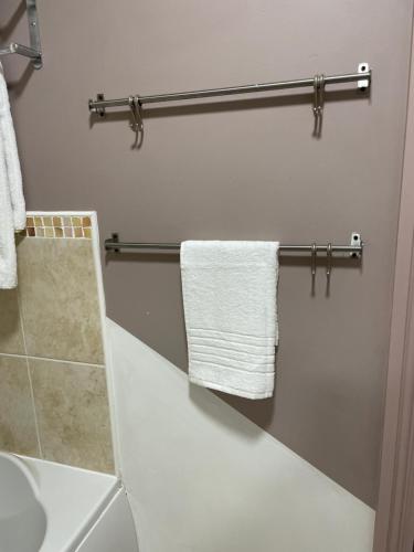 uma casa de banho com toalhas brancas penduradas num toalheiro em LanEnd House em Whiston