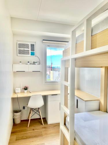 Un dormitorio con escritorio y literas. en Eurto Stay, en Mandaue