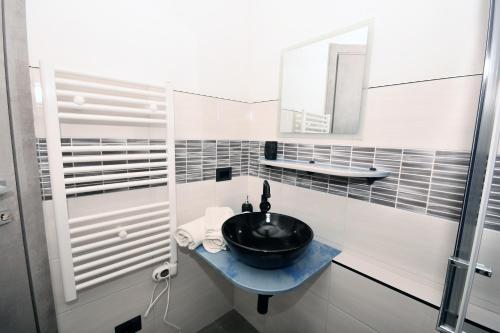 La salle de bains est pourvue d'un lavabo noir et d'un miroir. dans l'établissement Camera di Molly, à Leivi
