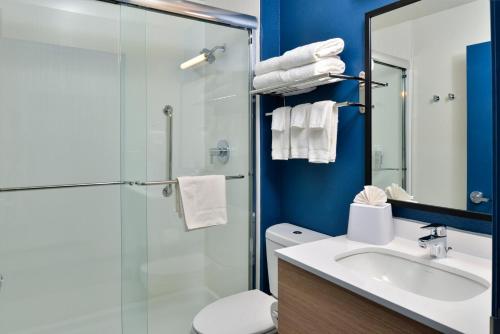 a bathroom with a toilet and a sink and a shower at Spark By Hilton Dallas Market Center in Dallas