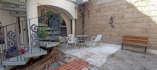 un patio con mesa, sillas y una valla en Hotel Teui Formarte, en Celaya