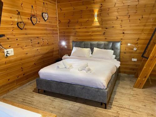 a bedroom with a large bed in a wooden wall at Pnina BaMarom in Sifsufa