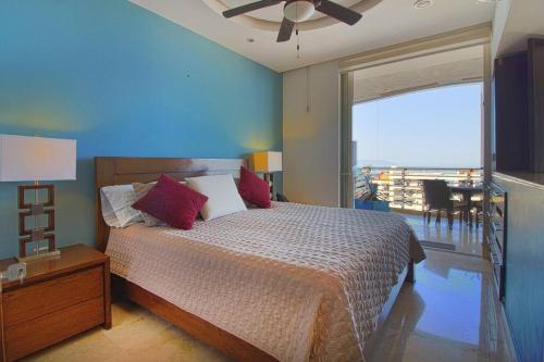 a bedroom with a bed with a blue wall at Pinnacle Resort-Style Condo - Luxurious Balcony in Puerto Vallarta