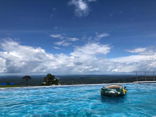 una piscina con un barco en el agua en Guayupes Hotel de Aventura, en Guamal