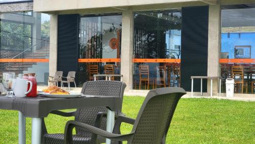 a table and chairs with a plate of food on it at Guayupes Hotel de Aventura in Guamal
