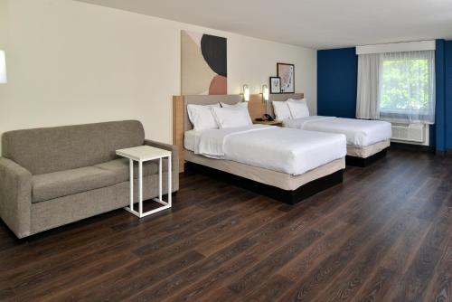 a hotel room with two beds and a couch at Spark By Hilton Dallas Market Center in Dallas