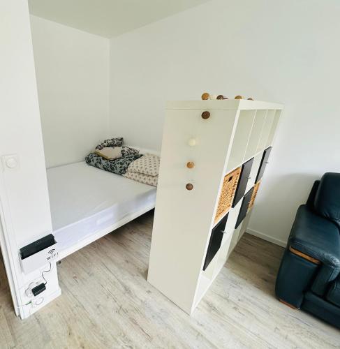 - une chambre avec des lits superposés blancs et une chaise bleue dans l'établissement Très agréable studio à Villeurbanne, à Villeurbanne