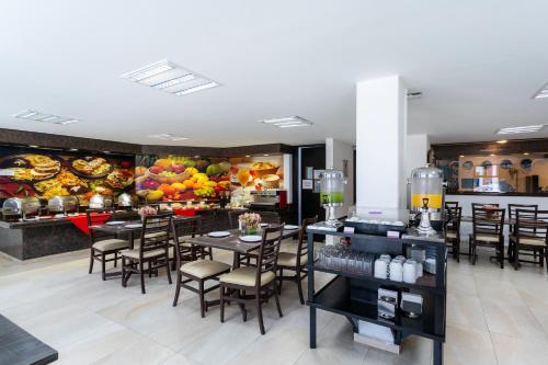 a restaurant with tables and chairs and a buffet at Sleep Inn Puebla Centro Historico in Puebla