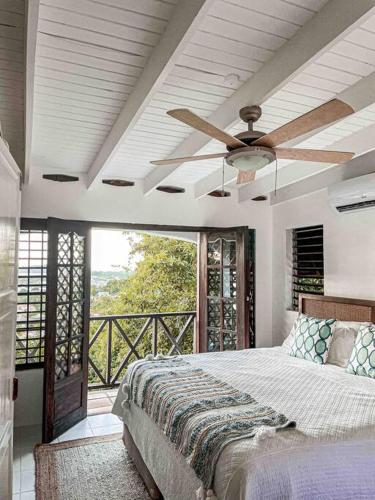 una camera da letto con un letto e un ventilatore a soffitto di Panoramic Ocean Views a Gros Islet