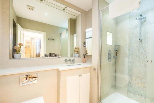 a bathroom with a shower and a sink and a mirror at Harrods-southKensington-HydePark-Marylebone-Knightsbridge in London