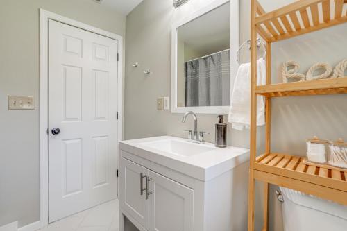a white bathroom with a sink and a mirror at Benton Harbor Home with Fire Pit - 2 Mi to Beach! in Benton Harbor