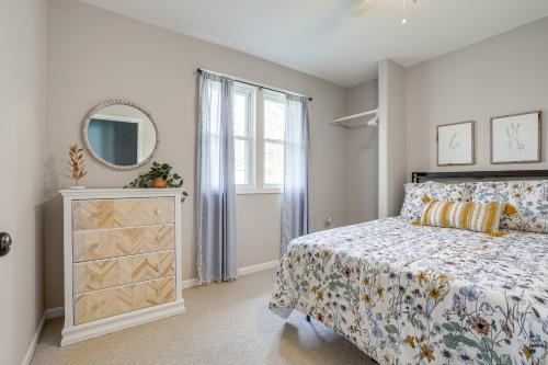 a bedroom with a bed and a mirror and a dresser at Benton Harbor Home with Fire Pit - 2 Mi to Beach! in Benton Harbor