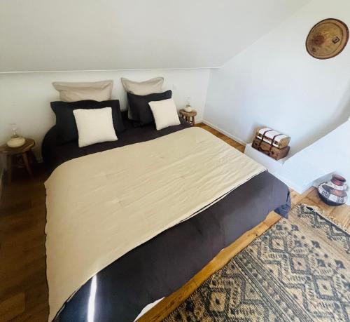 a bedroom with a large bed with black and white pillows at Villa Bellevue in Mailly-le-Château
