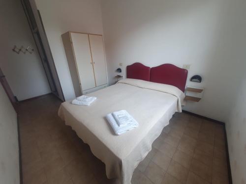 a bedroom with a bed with two towels on it at HOTEL IDEALE young people under 40 in Rimini